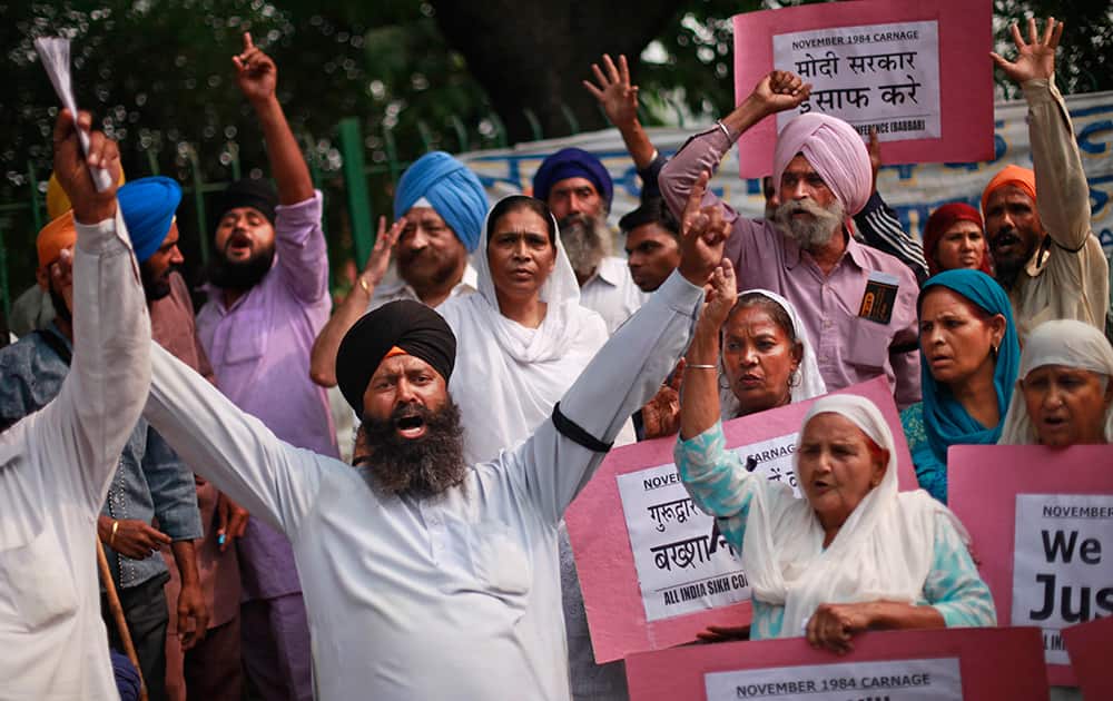 Sikhs hold placards as they shout slogans during a protest to demand justice for victims of the 1984 massacre of Sikhs following the assassination of Indira Gandhi, the then Prime Minister of India, in New Delhi.
