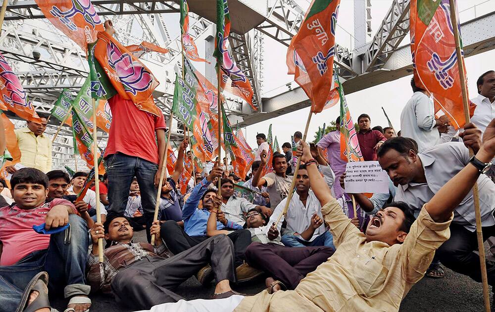 BJP supporters during their protest against State Government over political clash in Makra village, at Howrah Bridge in Kolkata.