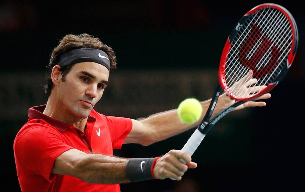 Roger Federer of Switzerland returns the ball to Milos Raonic of Canada during their quarterfinal match at the ATP World Tour Masters tennis tournament at Bercy stadium in Paris, France.