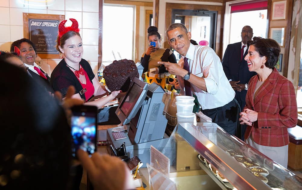 Amanda Schroeder holds a cake President Barack Obama ordered called 'Death by Chocolate' while campaigning with Rhode Island Democratic gubernatorial candidate Gina Raimondo, at Gregg's Restaurant and Pub in Providence, R.I.