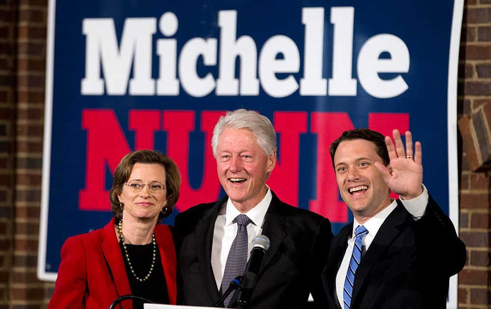 Former President Bill Clinton stands with Democratic candidate for Georgia Governor Jason Carter, and Democratic candidate for US Senate Michelle Nunn during a rally in Atlanta.