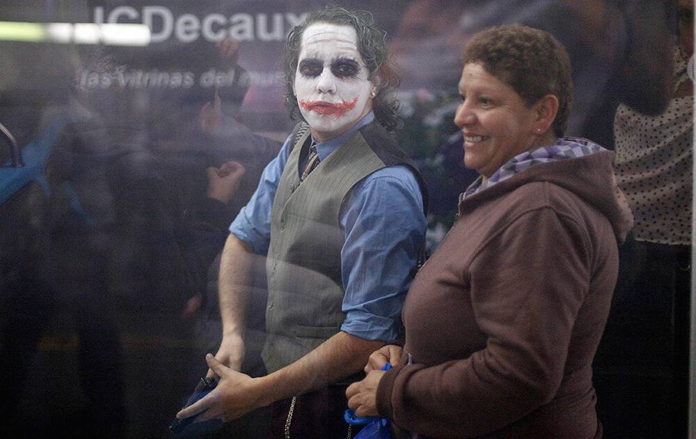 A man dressed as DC Comics super villain The Joker, holds a toy gun as he walks through a subway station, in Santiago, Chile.