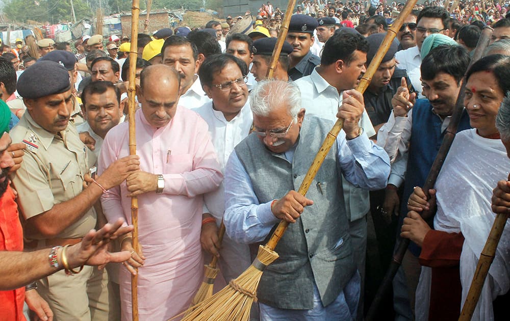 Haryana CM Manohar Lal Khattar sweeps the road after launching Swachh Bharat Abhiyan campaign on Haryana Day in Faridabad.