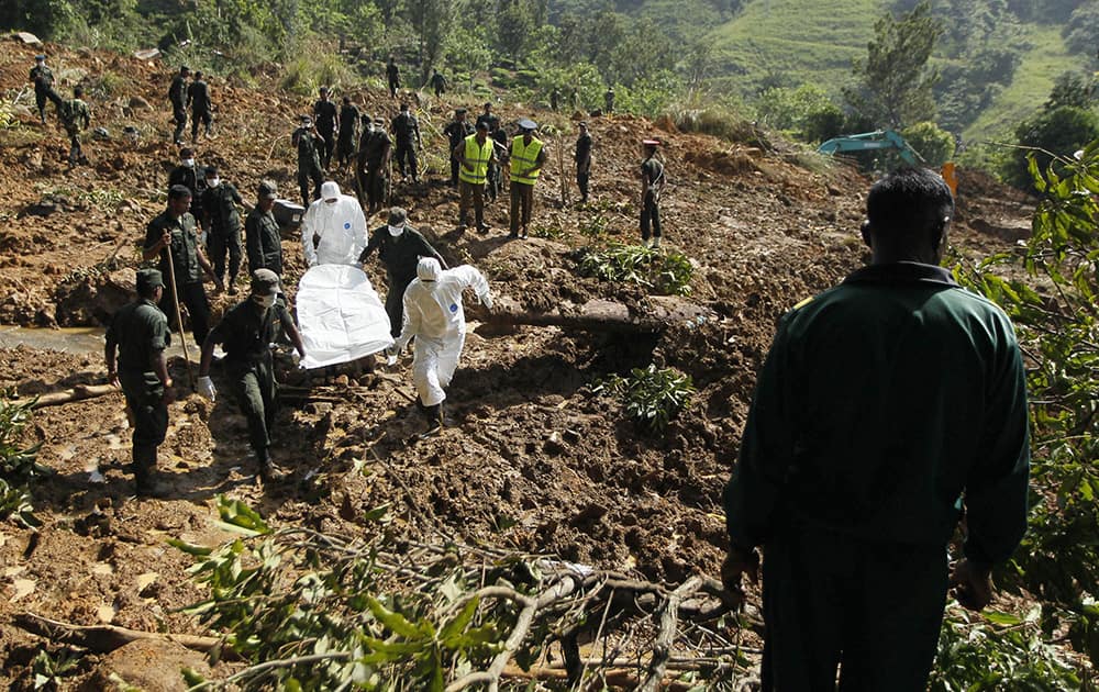 Sri Lankan army soldiers and forensic officers carry the body of a mudslide victim recovered from the site in Koslanda tea plantation in Badulla district, about 220 kilometers (140 miles) east of Colombo, Sri Lanka.