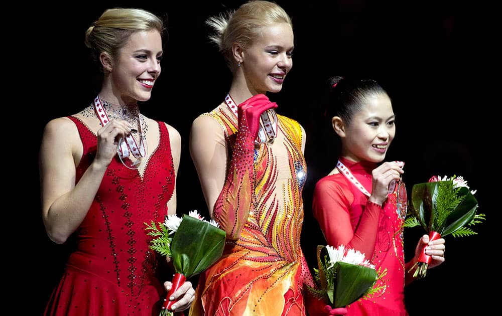 Gold medalist Anna Pogorilaya of Russia, center, poses with her medal with silver medalist Ashley Wagner of the United States, left, and bronze medalist Satoko Miyahara of Japan following the ice dance free dance program at Skate Canada International in Kelowna, British Columbia.