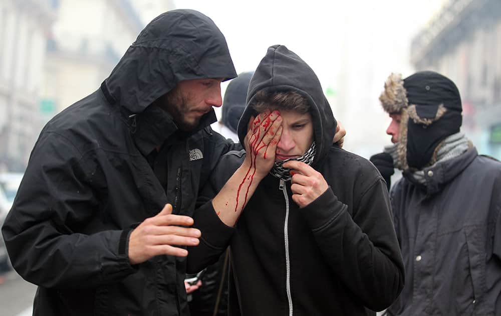 A protestor injured during clashes with police on the sidelines of a demonstration against police violence is tended to by another protestor in Nantes, western France.