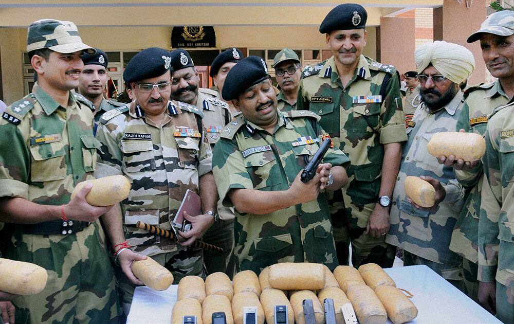 BSF officers show drugs and weapons seized near Indo-Pak border outpost at Boharwadala in Amritsar.