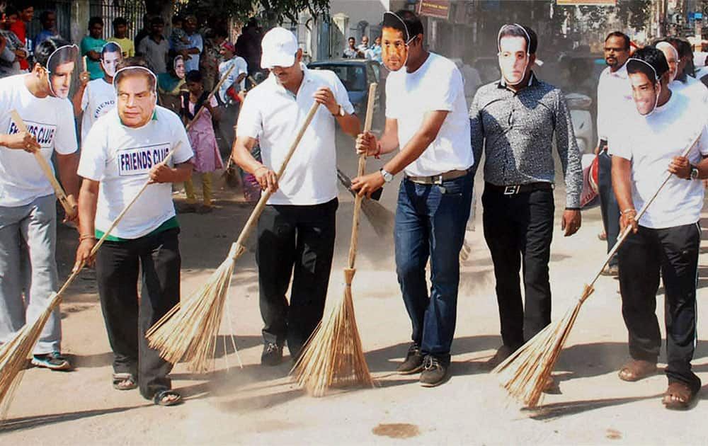 Members of Friends Club wearing masks of celebrities in a cleanliness drive during `swachh bharat abhiyan` in Guwahati.
