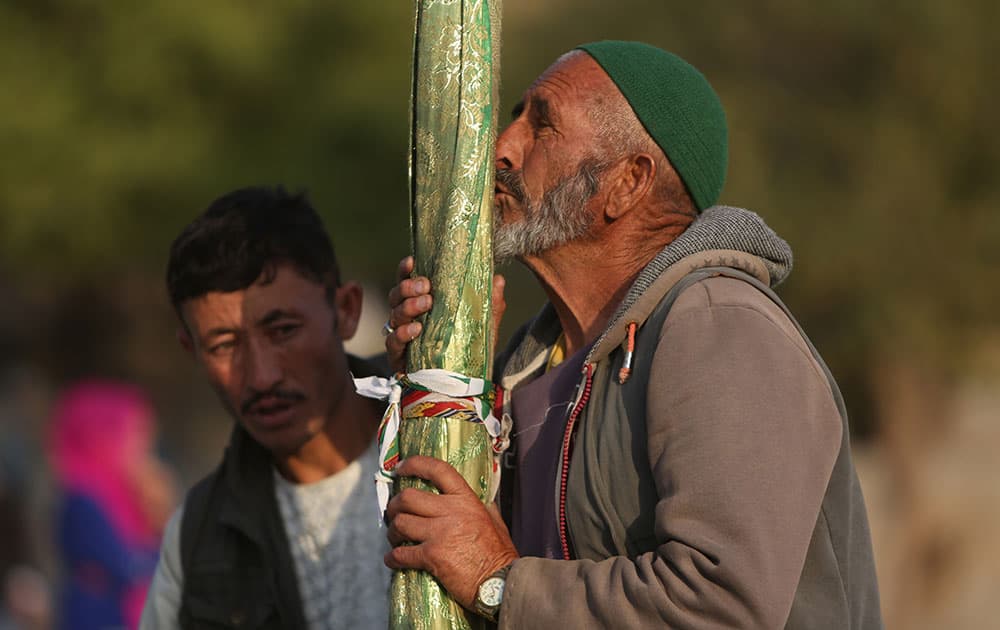 An Afghan Shiite man kisses the holy mace for blessings ahead of Islam's Muharram holy month at the Karti Sakhi shrine in Kabul, Afghanistan.