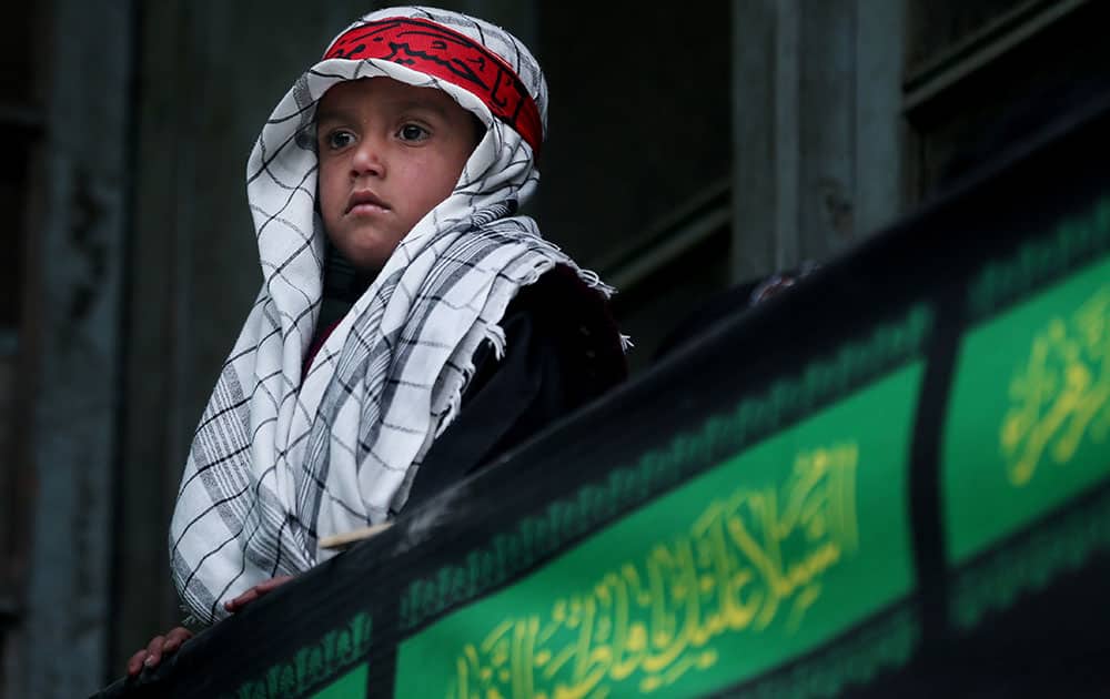 An Afghan Shiite boy watches a religious ceremony ahead of the Ashoura holiday, in Kabul, Afghanistan.