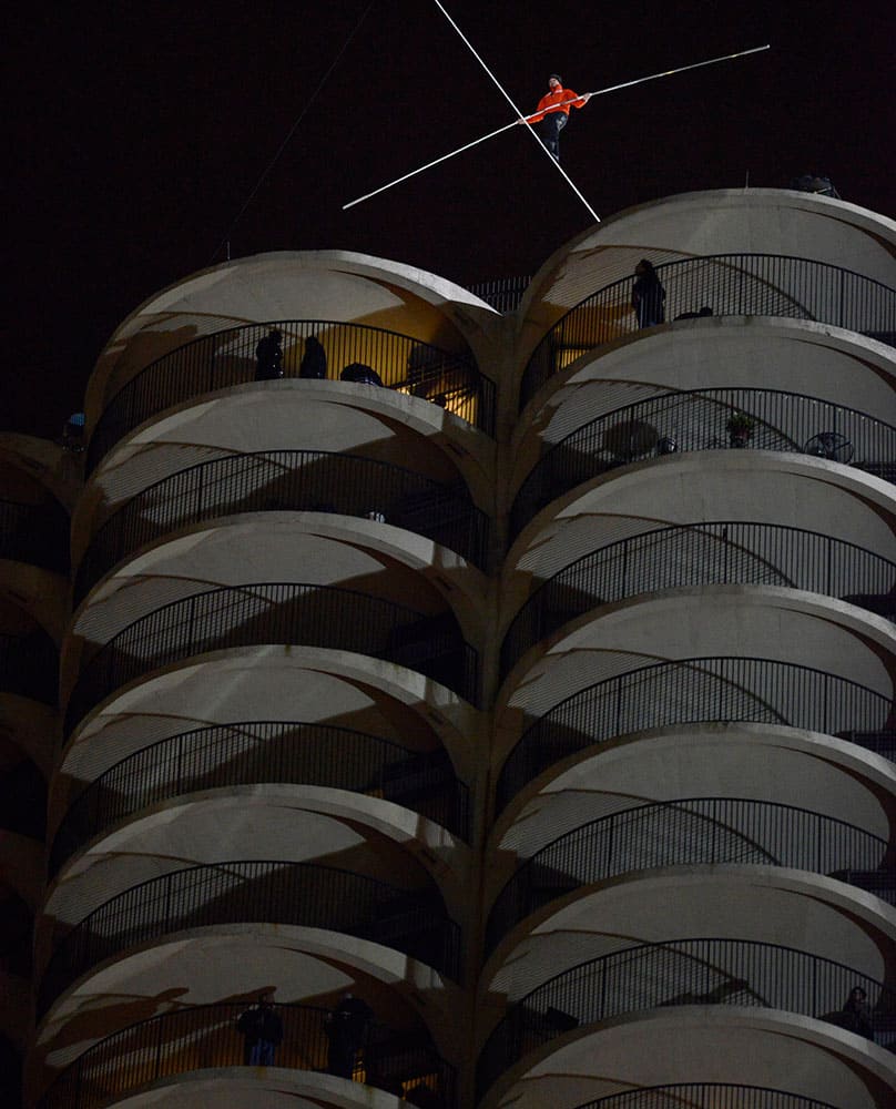 Daredevil Nik Wallenda begins his walk on a tightrope uphill at a 19-degree angle from the Marina City west tower across the Chicago River to the top of the Leo Burnett Building in Chicago.