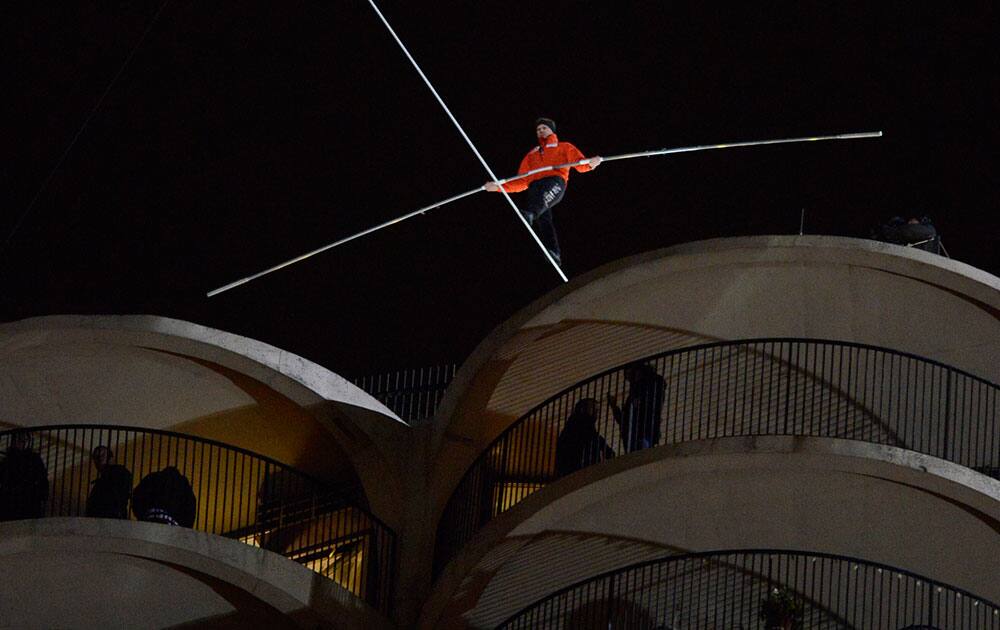 Daredevil Nik Wallenda begins his tightrope walk uphill at a 19-degree angle from the Marina City west tower across the Chicago River to the top of the Leo Burnett Building in Chicago.