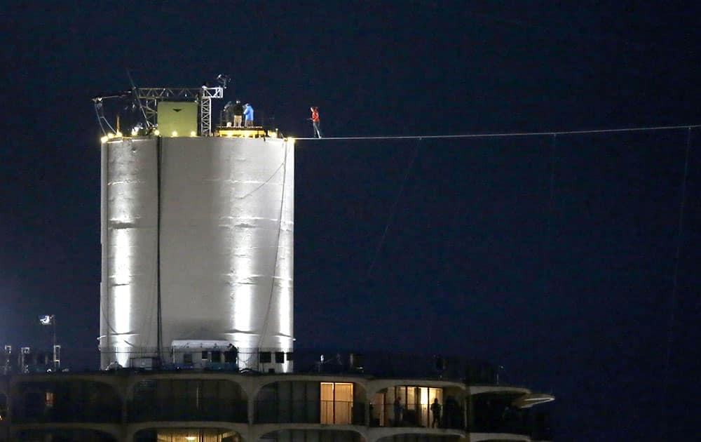 Daredevil Nik Wallenda, steps out on the wire backwards, for a live television show before his tightrope walk uphill at a 19-degree angle, from the Marina City west tower across the Chicago River to the top of the Leo Burnett Building in Chicago.