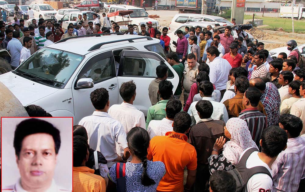 **COMBO** People gather around the vehicle in which a property dealer Virender (inset) was shot in Gurgaon.