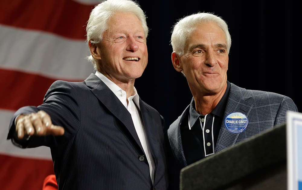 Former President Bill Clinton, left, and Florida Democratic gubernatorial candidate Charlie Crist wave to supporters at a campaign event, in Orlando, Fla.