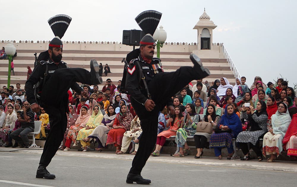 Pakistani border guards perform high kicks during a flag lowering ceremony after a Sunday suicide bombing, in Wagah.