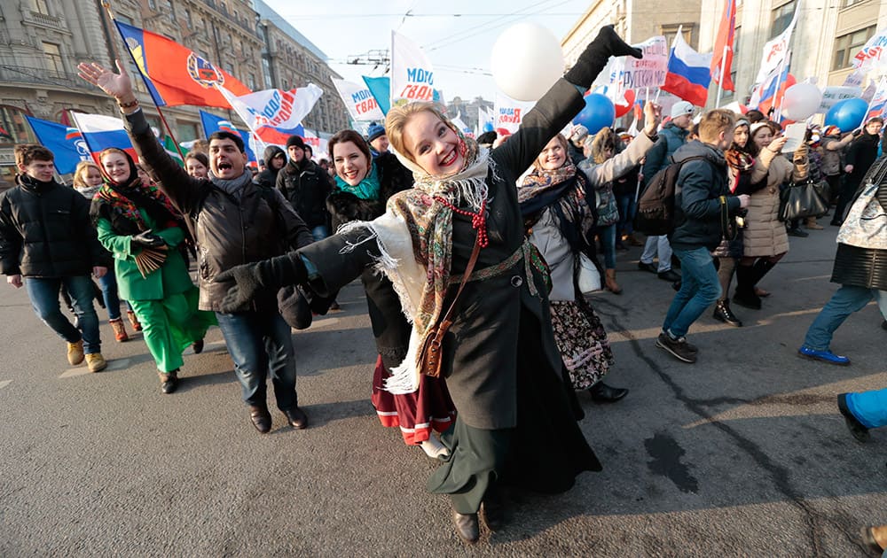 Supporters of pro-government groups with Russian flags dance as they march through downtown Moscow under the slogan ‘We are united’ to mark People’s Unity Day, a public holiday in Russia.