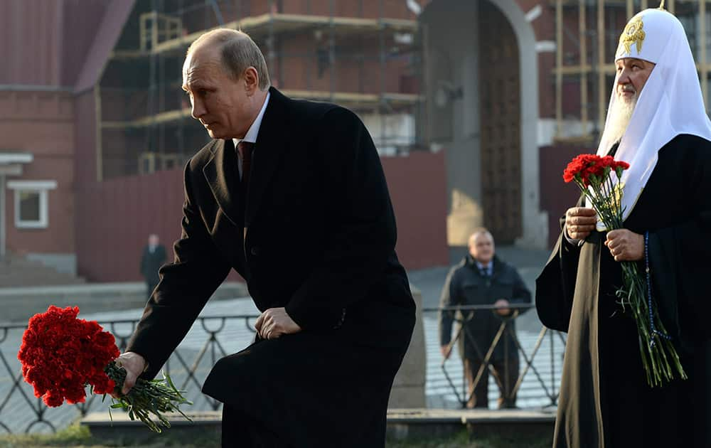 Russian President Vladimir Putin and Russias Patriarch Kirill, right, lay flowers during a ceremony at the Red Square in Moscow.