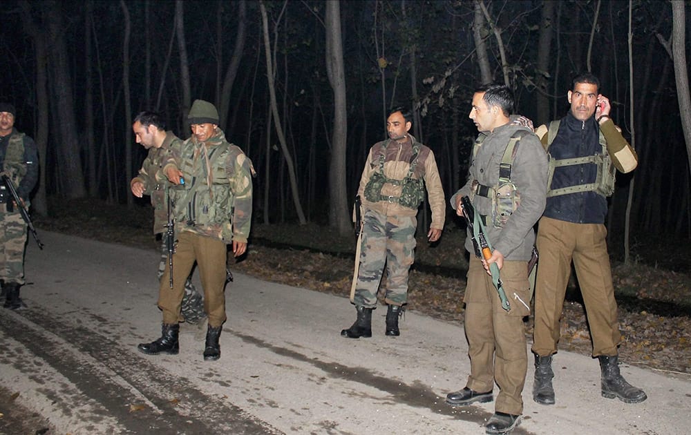 Army soldiers and J&K police inspect the area after militants opened fire on a police bus in Awantipora.