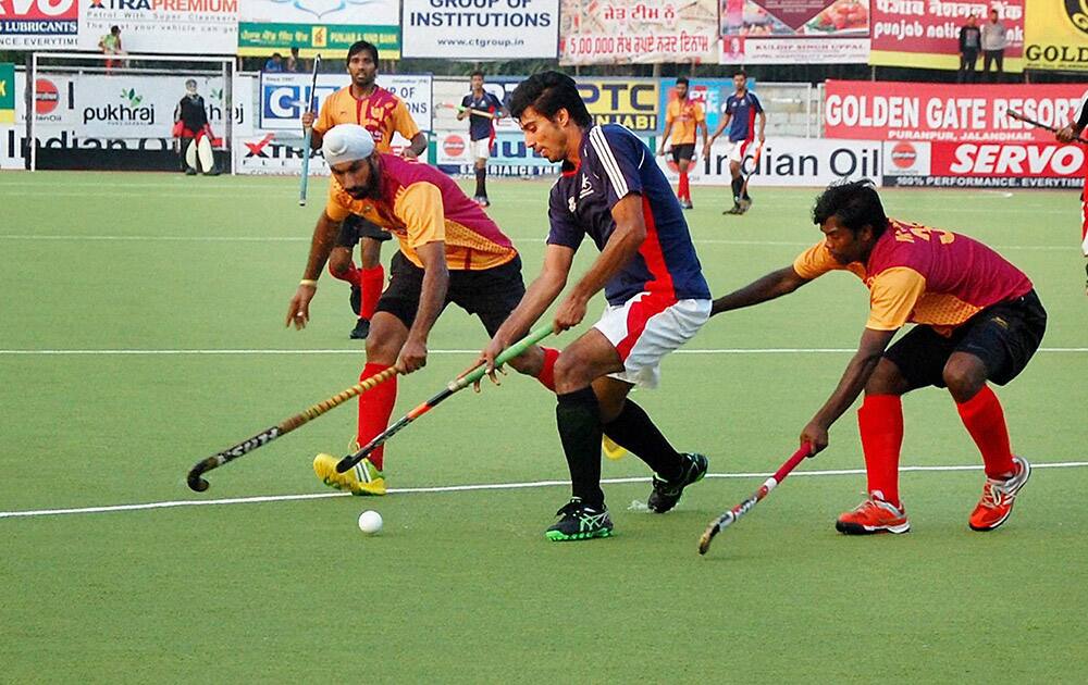 Players of Punjab XI, Pakistan (blue) and Punjab National Bank, Delhi (yellow) hockey teams compete during the Surjit Singh Hockey Tournament in Jalandhar.