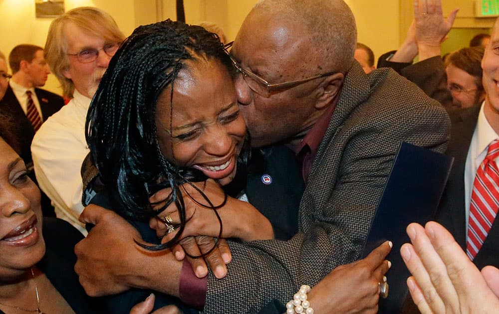 Republican Mia Love celebrates with her father, Jean Maxime Bourdeau, after winning the race for Utah's 4th Congressional District during the Utah State GOP election night watch party, in Salt Lake City. 