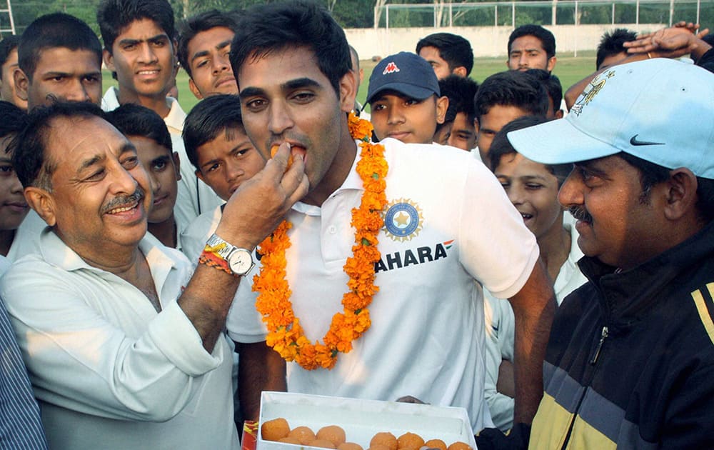 Coach and local people congratulate Indian Cricketer Bhuvenshwar Kumar after he won the ICC peoples choice award in Meerut.