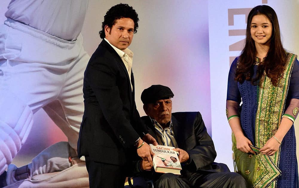 Cricket legend Sachin Tendulkar presents a copy of his autobiography Playing It My Way to his first coach Sir Ramakant Achrekar as his daughter Sara looks on, during the books launch function in Mumbai.