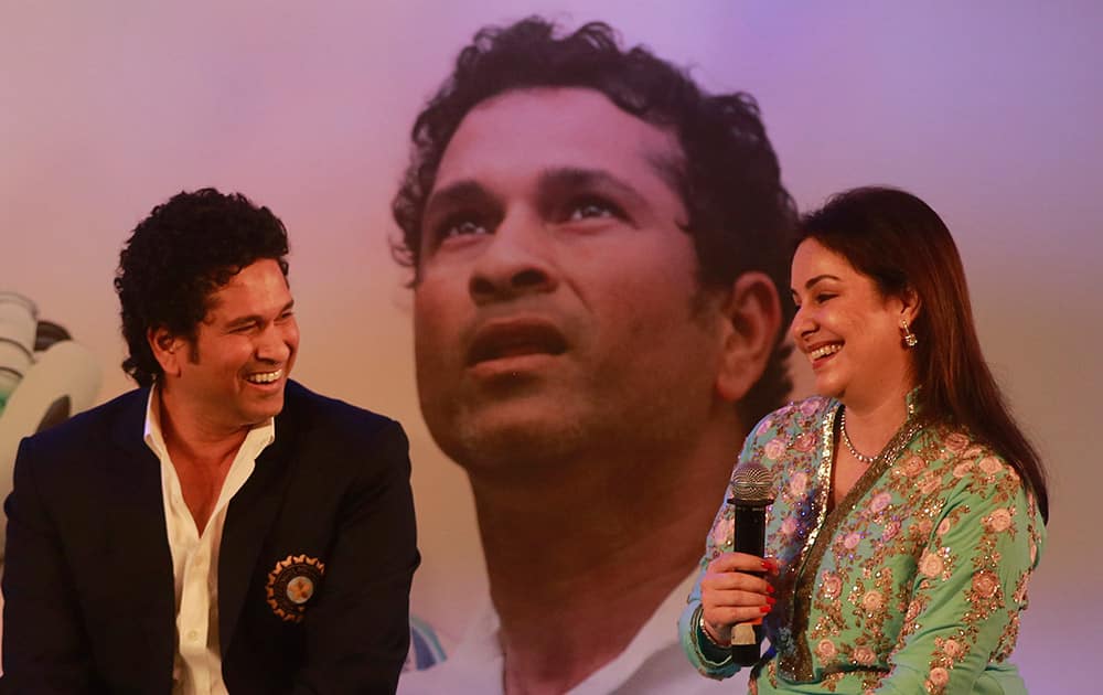 Retired cricket great Sachin Tendulkar, shares a lighter moment with his wife Anjali during the launch of his autobiography, 'Playing It My Way,' in Mumbai.