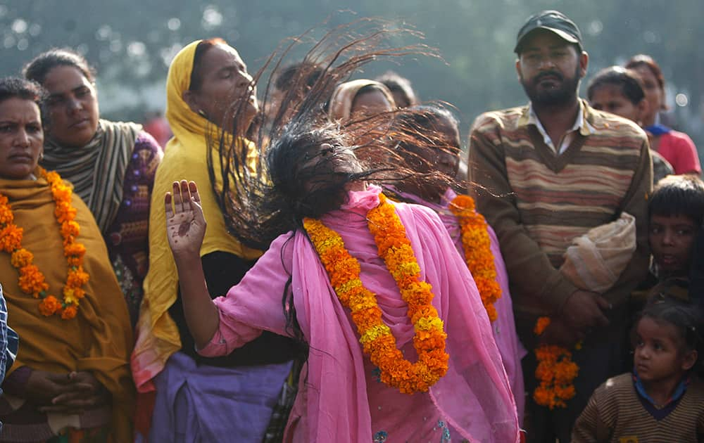 A devotee whirls her head to the beat of drums as a ritualistic performance during the annual Jhiri Fair at Kanachack village on the outskirts of Jammu.