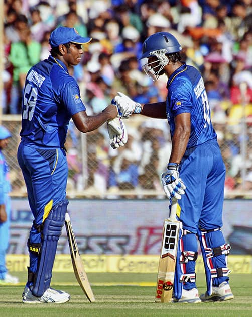 Sri Lankan batsman Angelo Mathews congratulates Kumar Sangakkara on scoring a half century during the 2nd ODI Match against India in Ahmedabad.