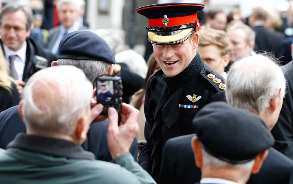 Britain's Prince Harry meets veterans from past and more recent conflicts, as he visited the Westminster Field of Remembrance in London.