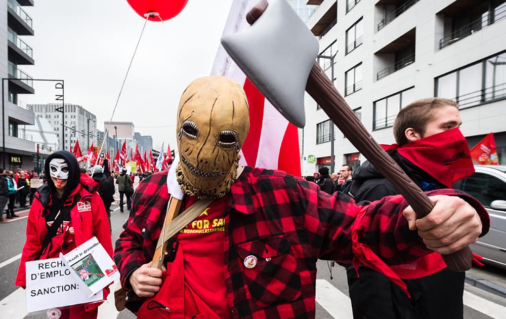 A worker holds a fake axe during a national trade union demonstration in Brussels.