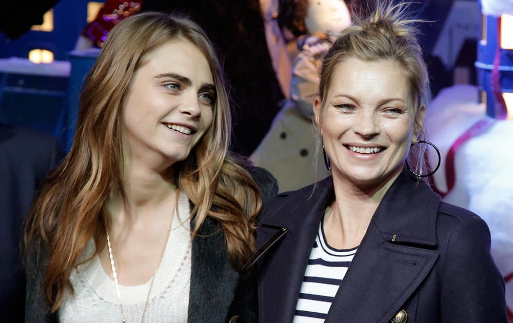 British models Cara Delevingne and Kate Moss pose during a photocall as they attend the Magical Christmas Journey event hosted by Burberry, in Paris, France.