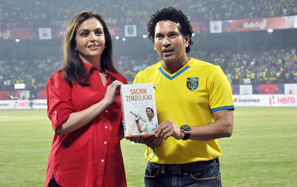 Cricket legend and Kerala Blasters FC co-owner Sachin Tendulkar with Nita Ambani showing his recently launched autobiography Playing It My Way during an ISL match in Kochi.