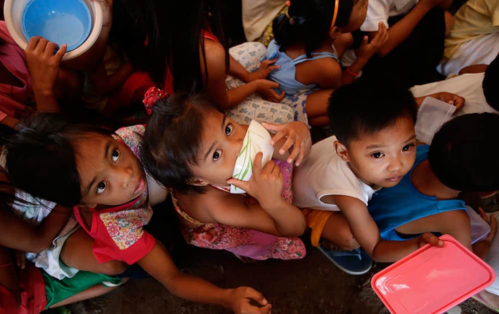 Children survivors queue up for free meals being distributed by a charitable organization at the 'tent city' for typhoon victims in Tacloban, Leyte province, in central Philippines.