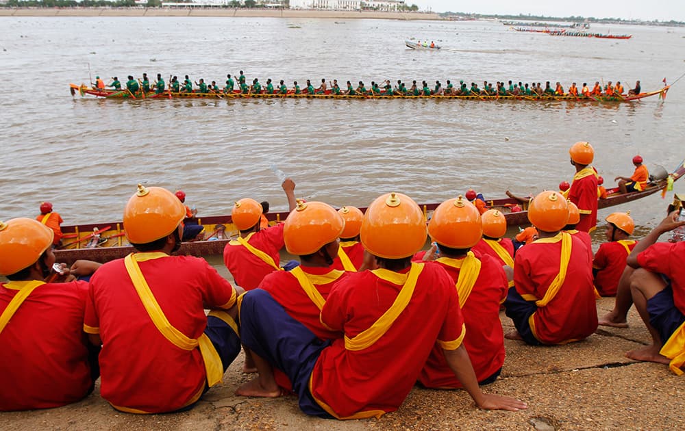 The Royal Palace guards at Tonle Sap river bank watch boatmen rowing their boat in front of Royal Palace in Phnom Penh, Cambodia. The three-day annual festival, started Wednesday, dedicates to the kingdom's ancestral naval warriors.