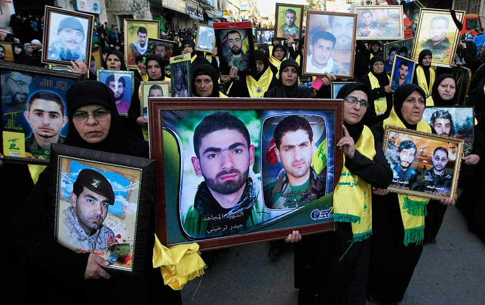 Lebanese Hezbollah supporters carry pictures of Hezbollah fighters who were killed in battle in Syria and against Israel, during a rally to mark the 13th day of Ashoura, in the southern market town of Nabatiyeh, Lebanon.