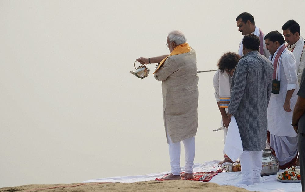 Prime Minister Narendra Modi offers prayers with priests at the Assi Ghat.