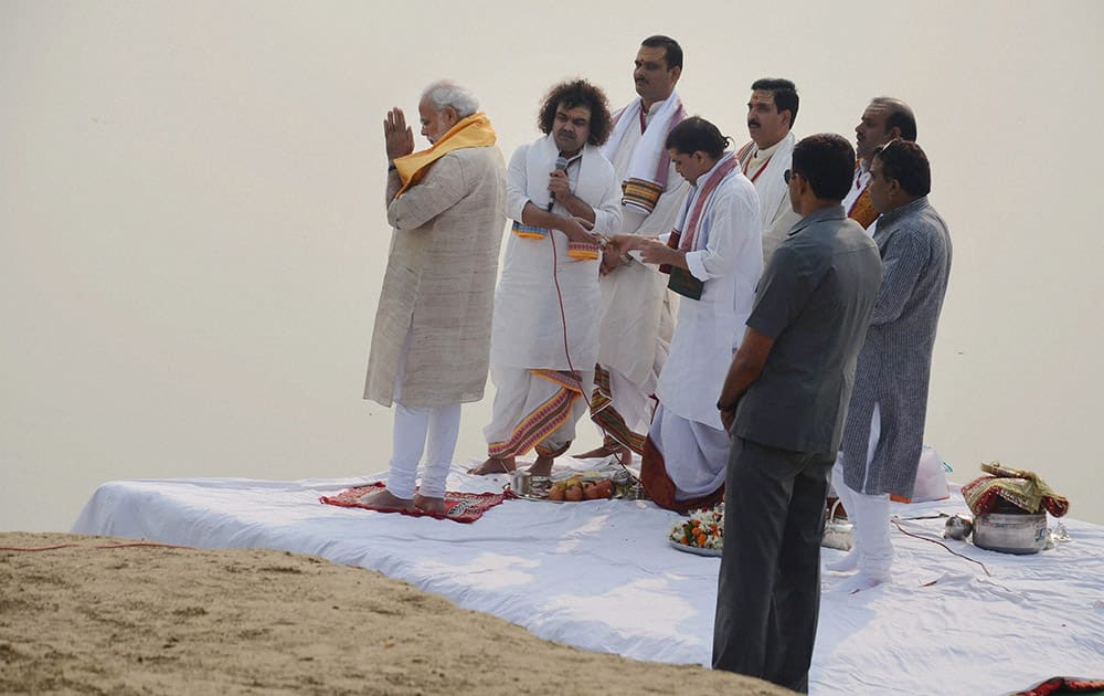 Prime Minister Narendra Modi offers prayers with priests at Assi Ghat in Varanasi.