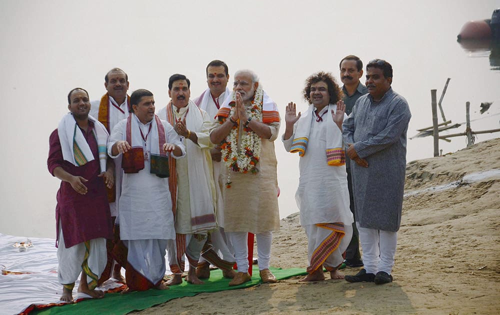 Prime Minister Narendra Modi offers prayers with priests during the launch of Namami Gange project at Assi Ghat in Varanasi.