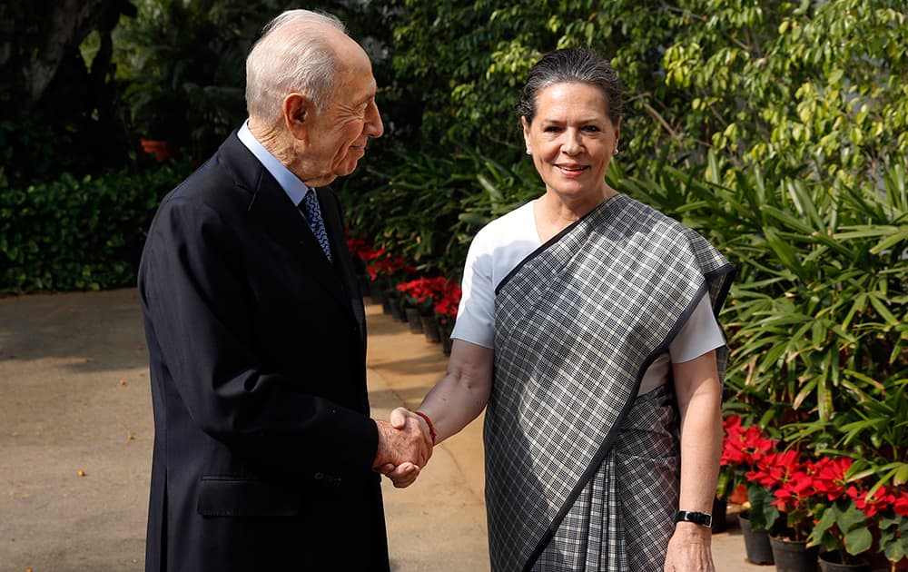 Sonia Gandhi, shakes hands with former Israeli President Shimon Peres, on his arrival at her residence in New Delhi.