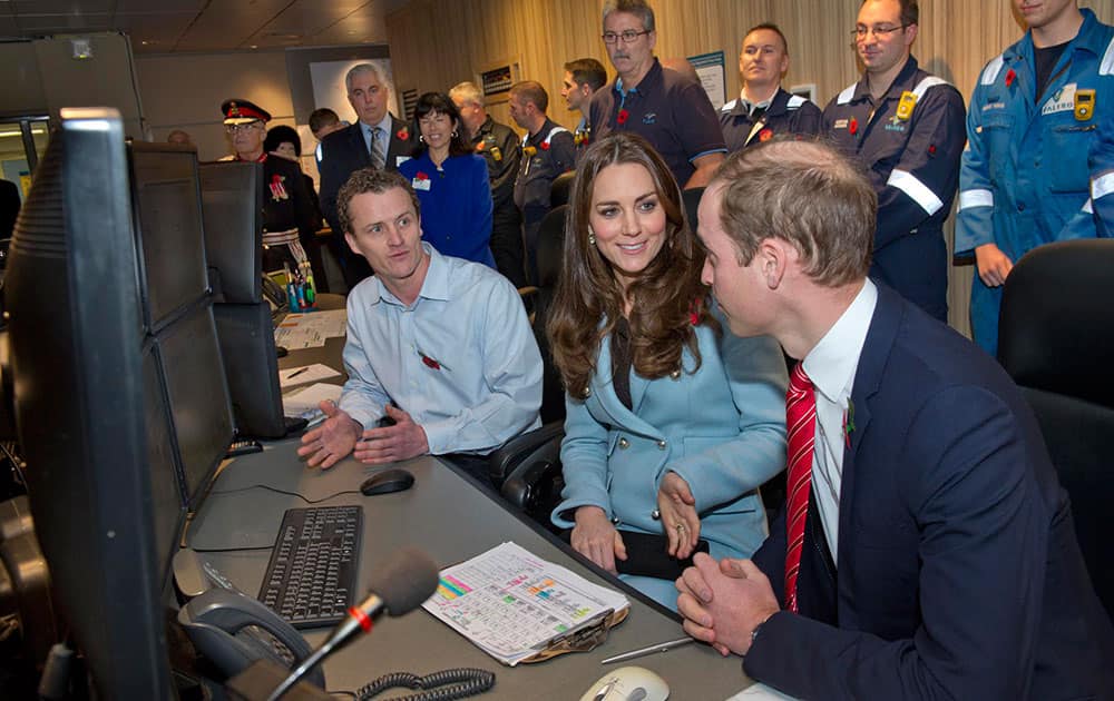 William Richards, left, shows Kate, Duchess of Cambridge and Prince William, right, the main control room at their visit to the Valero Pembroke Refinery in west Wales.