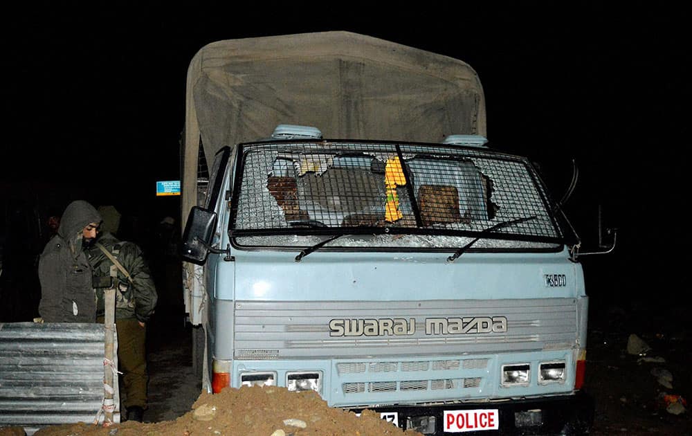 Security forces personnel stands near the CRPF vehicle which attacked by militants at Qazigund Srinagar-Jammu National highway in South Kashmir’s Anantnag district.