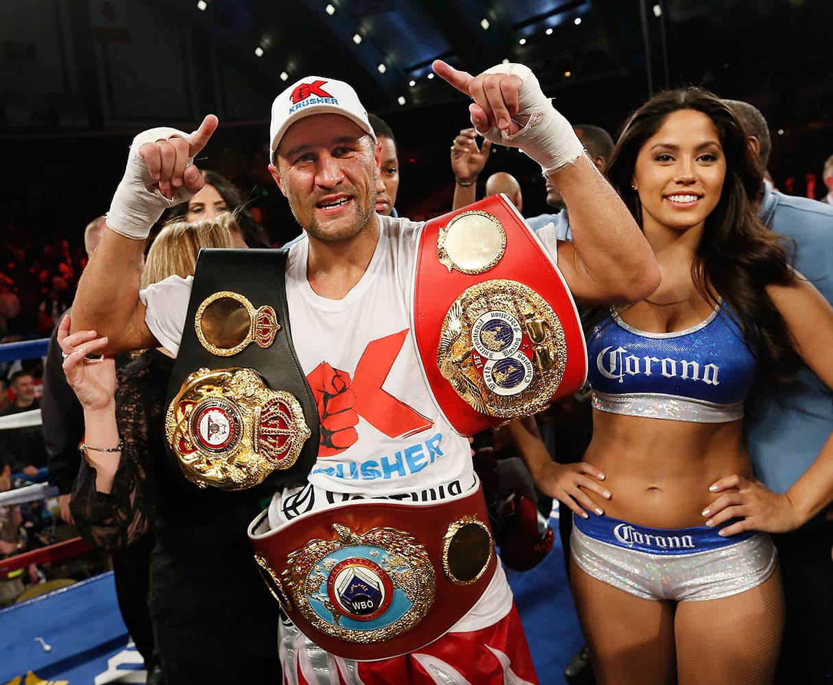 Sergey Kovalev of Russia poses with the belts after beating Bernard Hopkins of Philadelphia, PA in the 12th round of the Main Event IBF, WBA and WBO Light Heavyweight Titles boxing in Atlantic City, N.J.