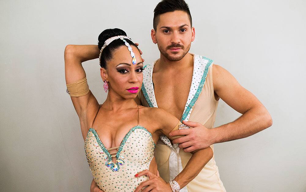 Salsa dancers Sheila De Jesus from Puerto Rico, left, and Davide Gatto from Italy, right, pose for a picture before they perform during the Madrid Salsa Festival, Spain.