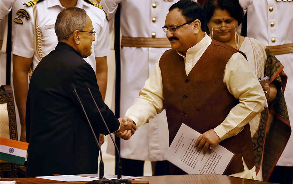 President Pranab Mukherjee shakes hands with the new Cabinet minister JP Nadda after administering him oath of office at the swearing-in ceremony at Rashtrapati Bhavan in New Delhi.