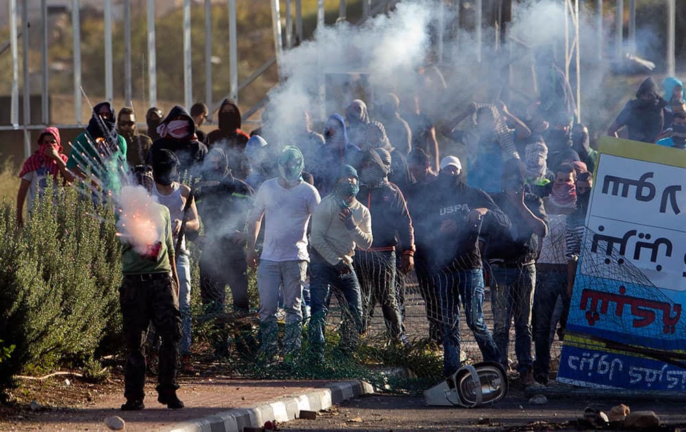 Israeli Arab protesters, one setting off a firework, clash with Israeli riot police during a protest over the fatal shooting of a 22-year-old Arab Israeli who appeared in video footage to be retreating from police, in the Arab village of Kfar Kana, northern Israel.