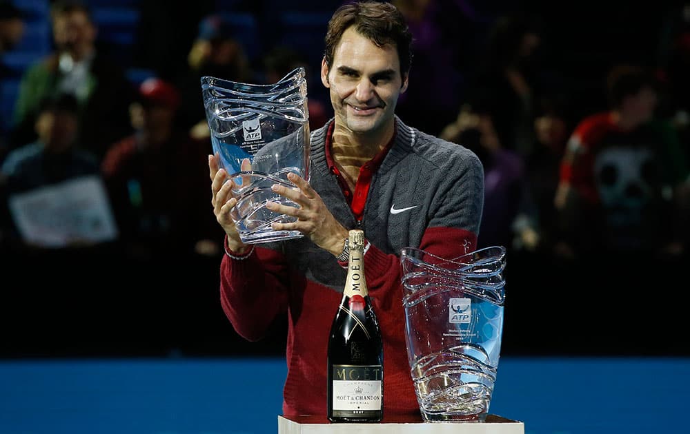 Switzerland’s Roger Federer poses for the cameras with two awards the ATP World Tour Sportsmanship Award and the ATP World Tour Fans’ Favourite Award following his match against Canada’s Milos Raonic at the ATP World Tour tennis finals at the O2 arena in London.