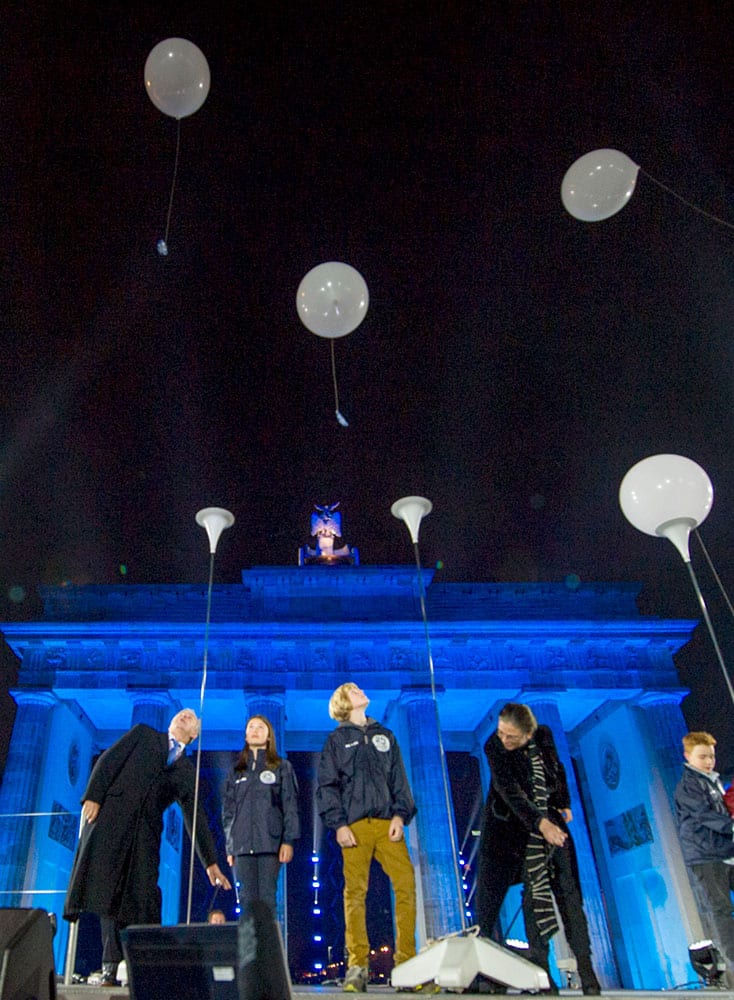 Balloons of the art installation 'Lichtgrenze 2014' flue away in front of Brandenburg Gate during the central event commemorating the fall of the wall in Berlin, Germany, Sunday, Nov. 9, 2014. 25 years ago - on Nov. 9, 1989 - the East-German government lifted travel restrictions and thousands of East Berliners had pushed their way past perplexed border guards to celebrate freedom with their brethren in the West.