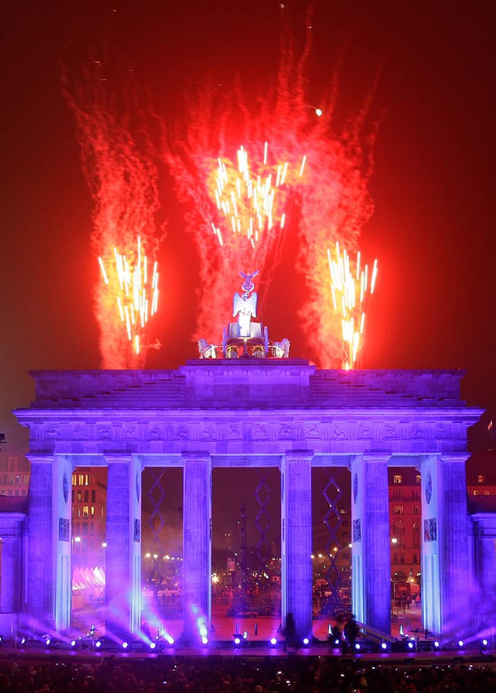 Fireworks explode behind Brandenburg Gate during the central event commemorating the fall of the wall in Berlin, Germany.